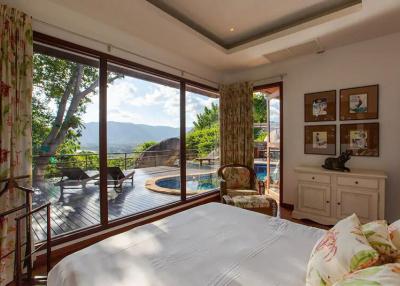 Spacious bedroom with a view of the pool and mountains