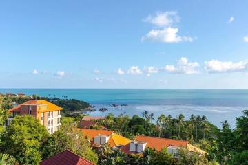 Scenic ocean view from the property showing surrounding buildings and lush greenery