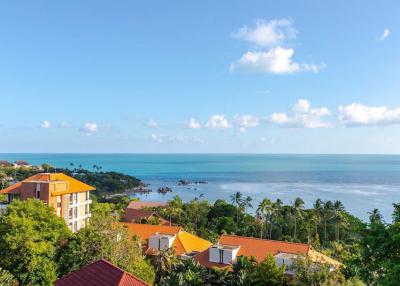Scenic ocean view from the property showing surrounding buildings and lush greenery