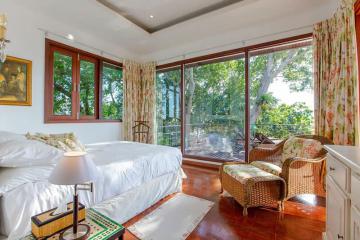 Bright and spacious bedroom with large windows and nature view