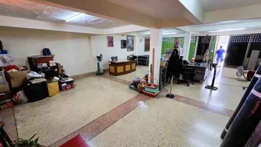 Spacious living room area with terrazzo flooring and cluttered with objects