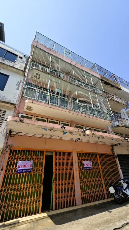 Exterior view of a multi-story residential building with balconies and protective railings