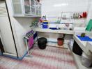 Spacious kitchen with tiled flooring and storage cabinets