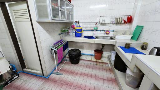 Spacious kitchen with tiled flooring and storage cabinets