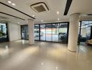 Spacious commercial building interior with large glass windows and glossy tiled flooring