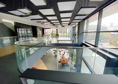 Modern office interior with glass walls and geometric ceiling design