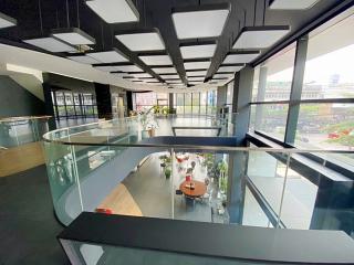 Modern office interior with glass walls and geometric ceiling design