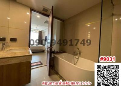 Spacious bathroom with bathtub and glass shower partition