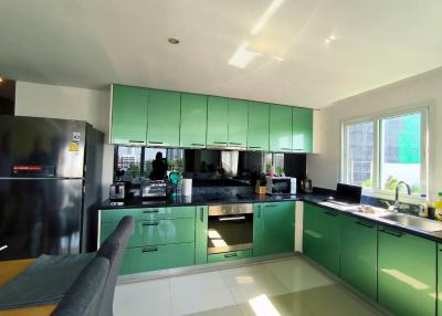 Modern kitchen with green cabinetry and stainless steel appliances