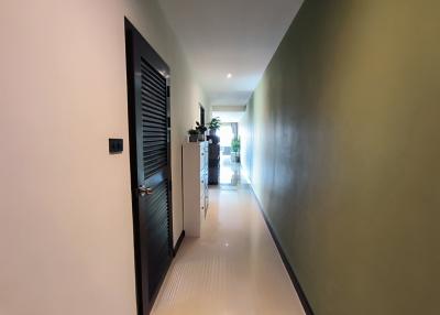 Bright and spacious hallway leading towards the living spaces with tiled flooring and neutral wall colors