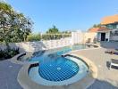 Inviting outdoor swimming pool with a hot tub and lounge area