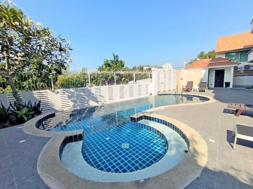 Inviting outdoor swimming pool with a hot tub and lounge area