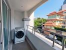 Spacious balcony with laundry machine and urban view
