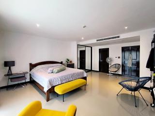 Spacious modern bedroom with king-sized bed and contemporary furniture