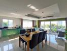 Spacious and well-lit open-plan kitchen with adjacent dining space featuring modern furnishings and large windows