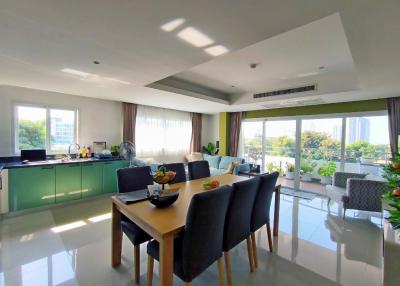 Spacious and well-lit open-plan kitchen with adjacent dining space featuring modern furnishings and large windows