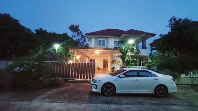 Twilight view of a two-story house with illuminated exterior and a car parked in the driveway