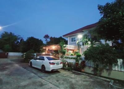 Twilight view of a suburban house with a parked car and illuminated porch