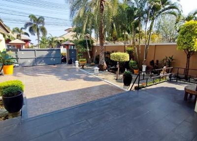 Spacious paved driveway with landscaped garden and gated entrance