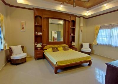 Spacious Bedroom with Wooden Furniture and Attached Bathroom