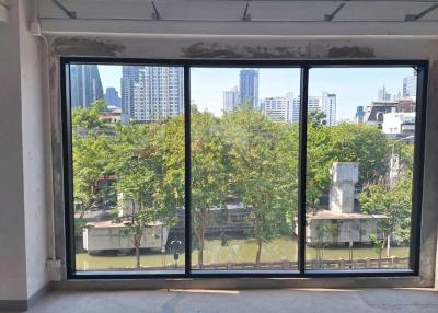 Spacious unfurnished room with large windows and a city view