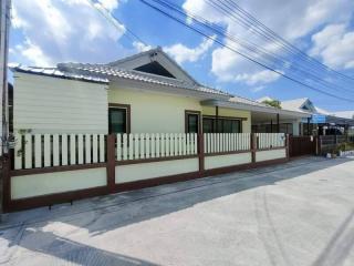 Suburban single-story house with off-white exterior and secure fencing