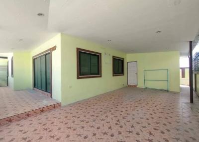 Spacious empty room with tiled flooring, multiple windows, and glass door