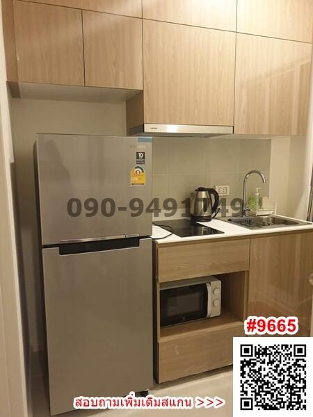 Modern compact kitchen with wooden cabinets, stainless steel appliances, and QR code