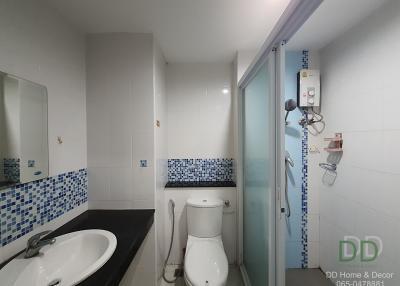 Modern bathroom interior with tiled walls, shower, toilet, and sink