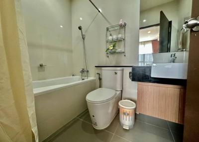 Modern bathroom with tub, toilet, and sink