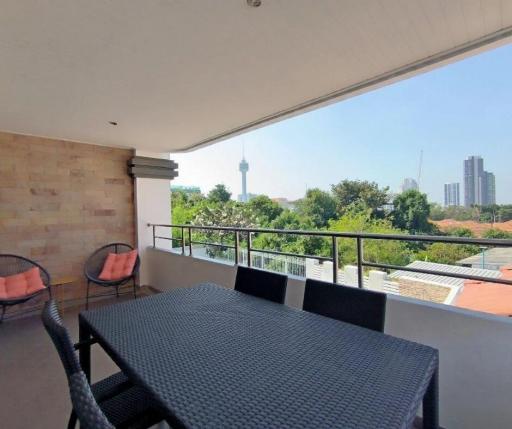 Spacious balcony with outdoor dining set and skyline view