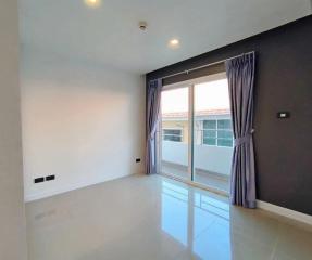 Empty bedroom with glossy tiled floor and natural light from window with curtains