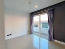 Empty bedroom with glossy tiled floor and natural light from window with curtains