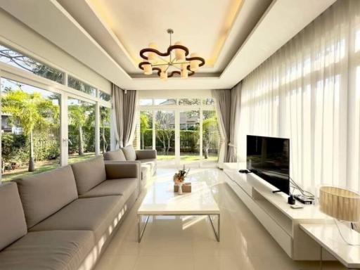 Spacious and sunlit living room with modern furniture and garden view