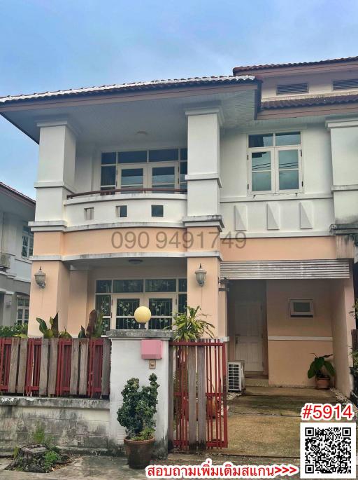 Two-story residential house with pink walls and a red fence