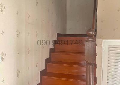Staircase with wooden steps and floral wallpaper