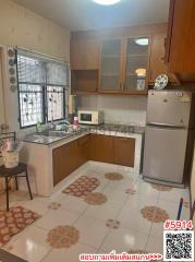 Spacious kitchen with wooden cabinets and tile flooring