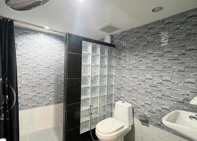 Modern bathroom with grey tile finish and glass shower enclosure