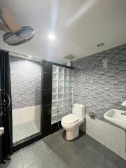 Modern bathroom with grey tile finish and glass shower enclosure