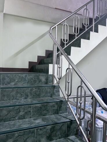 Modern staircase with stainless steel handrails and green marble steps