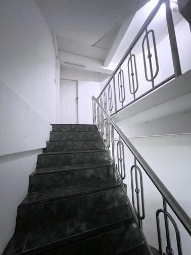 Interior stairway with black steps and white walls