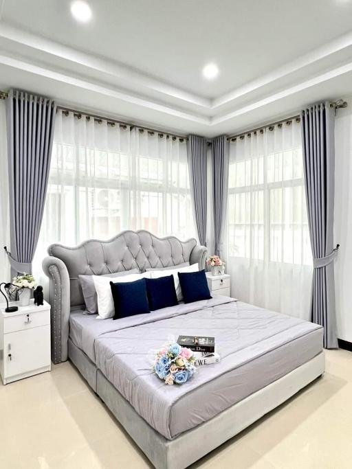Modern bedroom with elegant decor, large bed, and ample natural light