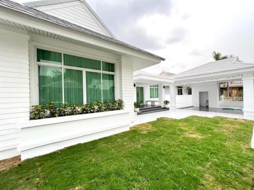 White single-story residential building with green lawn