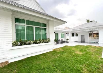 White single-story residential building with green lawn