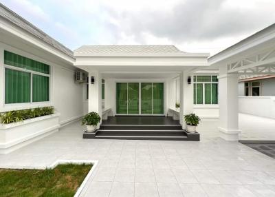 Modern single-level house with spacious front patio and green lawn