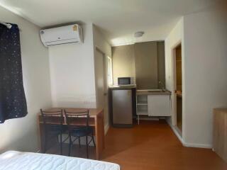 Compact bedroom with an attached kitchenette and air conditioning unit