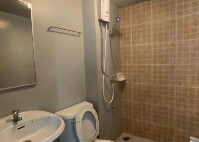 Compact bathroom with toilet, sink, and shower