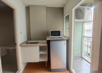 Compact kitchenette with modern appliances and wooden flooring