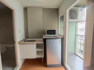 Compact kitchenette with modern appliances and wooden flooring