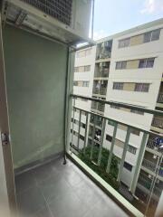 Small balcony with air conditioning unit and view of adjacent buildings